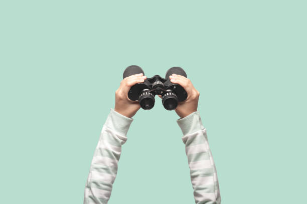 Woman with binoculars on green background