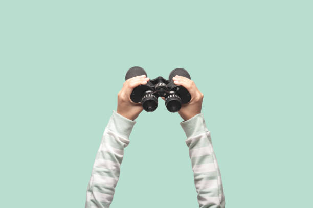 Woman with binoculars on green background Woman with binoculars on green background, looking through binoculars, journey, find and search concept. telescope photos stock pictures, royalty-free photos & images