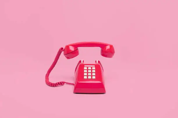 Retro pink telephone on pink background, Vintage style colors.