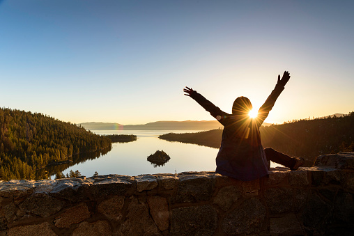 A woman embranced beautiful sunrise at Emerald Lake, California