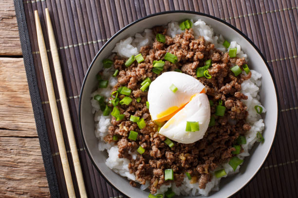 istock Japanese dish: spicy meat Soboro with egg poached and rice close-up in a bowl. horizontal top view 1037987630