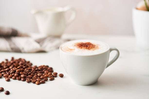 istock Cappuccino in a white ceramic coffee cup with roasted coffee beans 1037987980
