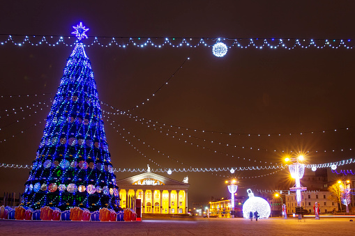 Festive decorated Christmas tree on square in winter Minsk. Celebration New Year and Xmas in night Minsk.