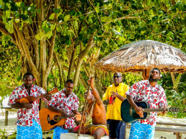 меланезийская группа играет музыку для туристов на пляже острова пеле, крошечного острова у северного побережья острова эфате в вануату - pele стоковые фото и изображения