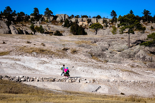 CREEL, MEXICO - Jan 2016: A native Raramuri couple walks through the barren landscape of the Valley of the Monks in Creel, near the Copper Canyon in northern Mexico