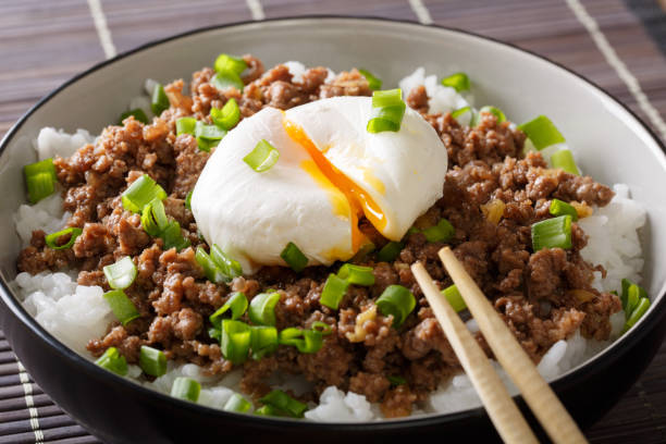 istock Japanese food: beef Soboro with egg poached, rice and green onion close-up in a bowl. horizontal 1037999812