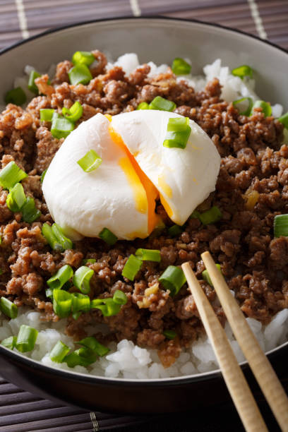 istock Beef Soboro with egg poached, rice and green onion close-up. vertical 1038000352