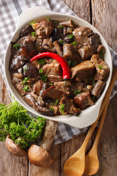 istock Stew beef with wild forest mushrooms and chili close-up. vertical top view 1038002900