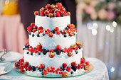 white layer cake decorated with berries, served with fireworks.