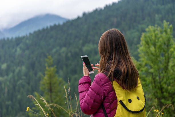 istock Tourist woman using smartphone and look in display outdoors in nature 1038029514
