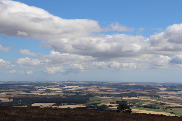 istock Fluffy white clouds in blue sky over hilltops 1038033762