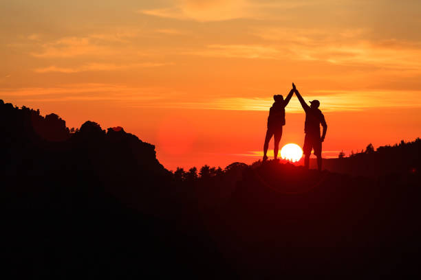 istock Teamwork couple celebrating in inspiring mountains sunset 1038039092