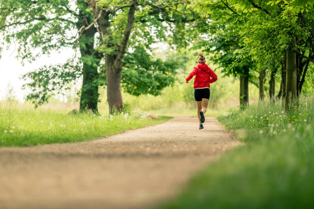 Running woman, enjoying summer day in park stock photo