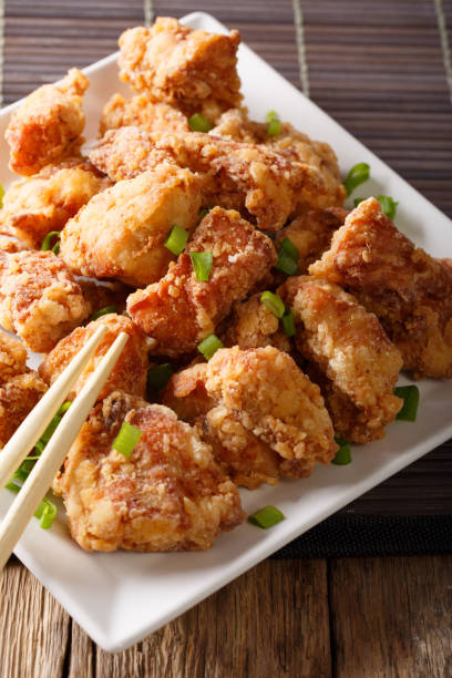 istock Spicy chicken karaage with lemon and green onion close-up. vertical 1038055450
