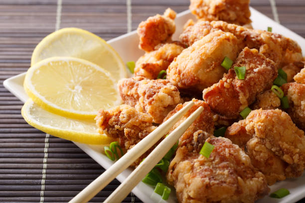 istock Japanese dish: fried chicken karaage with a lemon close-up on a plate. horizontal 1038056022