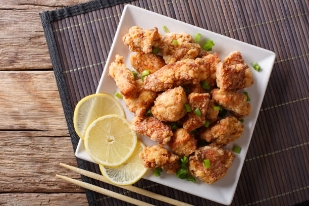 istock Portion fried chicken karaage with lemon and onion close-up on a plate. Horizontal top view 1038056092