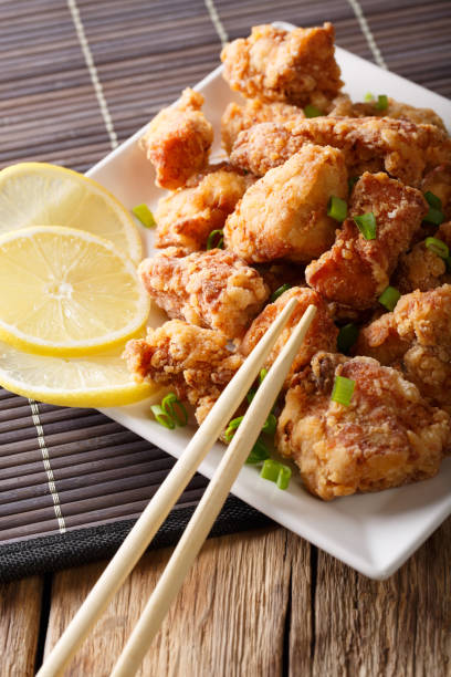 istock Fried chicken karaage with a lemon close-up. vertical, japanese style 1038056144