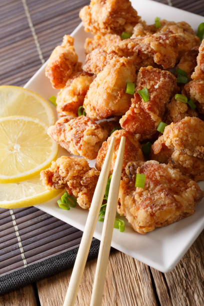 istock Tasty fried chicken karaage with a lemon close-up on a plate. vertical 1038056164