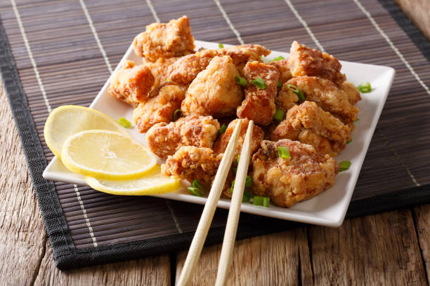 istock Japanese freshly prepared chicken karaage with lemon close-up on a plate. horizontal 1038056378