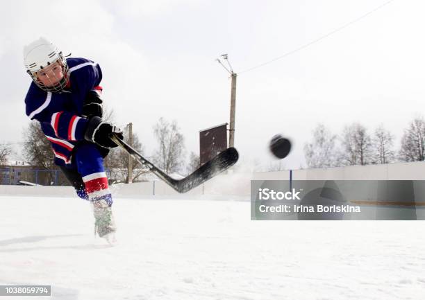 The Boy Plays Hockey On A Street Skating Rinka Boy On A Skating Rink Plays Hockey Stock Photo - Download Image Now