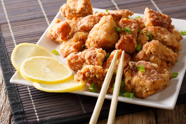 portion fried chicken karaage with lemon and onion close-up on a plate. horizontal - lemon food preparation portion imagens e fotografias de stock