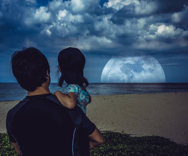 istock Father's day. Father carrying his daughter and looking at super moon. 1038060312