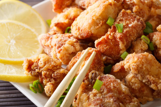 istock Japanese food: fried chicken karaage with lemon and green onion macro on a plate. horizontal 1038061090