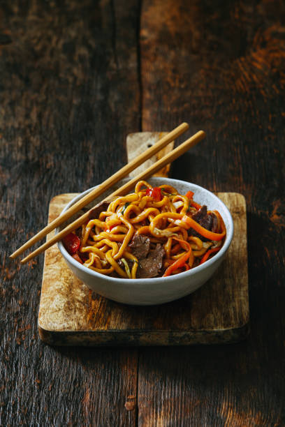 tazón de fuente con chow mein - chopsticks stir fried vegetable beef fotografías e imágenes de stock