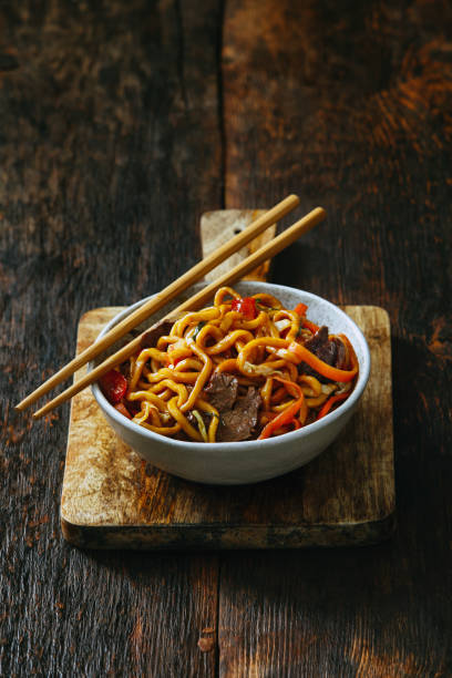 焼きそばとボウルします。 - chopsticks stir fried vegetable beef ストックフォトと画像