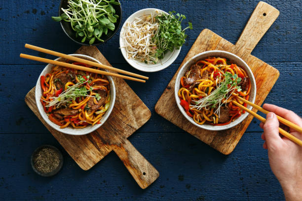 tazones de fuente con chow mein - chopsticks stir fried vegetable beef fotografías e imágenes de stock