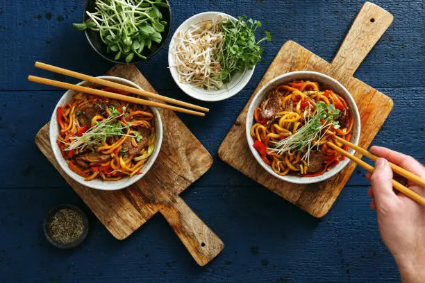 Bowls with chicken, beef and vegetables chow mein