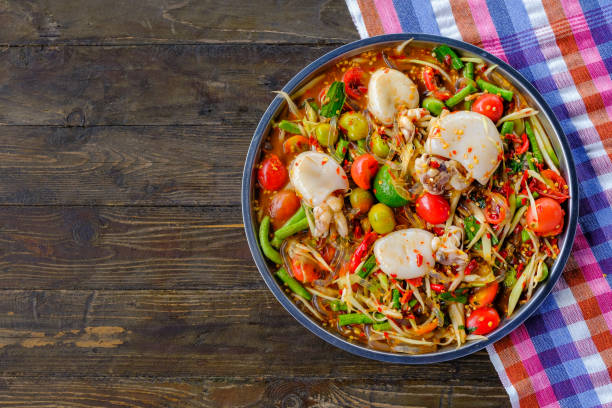 istock Som Tam Seafood squid (Spicy Papaya Salad) with salted crab, on wooden table ( Thai food) 1038074724