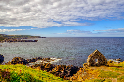 The rugged coastline of the Moray Firth at Portsoy with ruined building perchd on cliff tops taken in late summer.