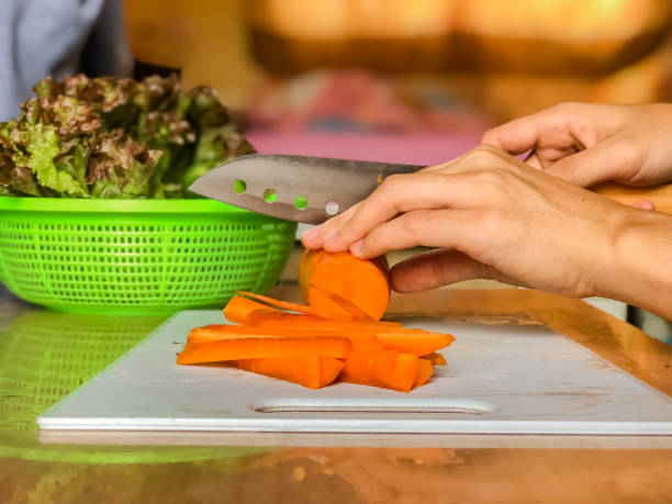 Woman cooking salad,human hands chopping vegetable,vegetarian,carrot,cucumber and red coral lettuce ,home cooking,healthy concept,Preparation of food