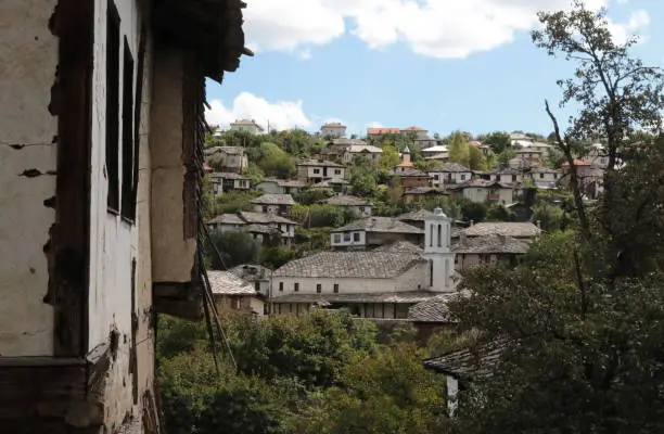 Photo of Old houses in the historical cultural reserve village of Dolen, Bulgaria. Dolen is famous with its 350 old houses – an example of 19th century Rhodopean architecture. The houses are typically built with overhanging top stories and the roofs are made out 