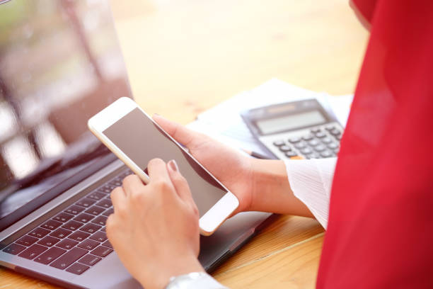 istock Attractive young Asian wearing red hijab  using her mobile smartphone at workspace desk. 1038133044