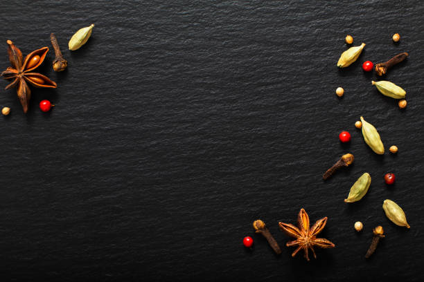 Food presentation background organic various exotic spieces on black slate board with copy spaceFood presentation background organic various exotic spieces on black slate board with copy space