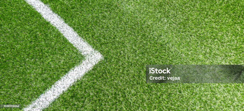 Green synthetic grass soccer sports field with white corner stripe line Green synthetic grass soccer football sports field with white corner stripe line. Top view Above Stock Photo