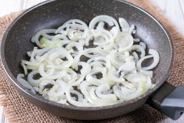 Chopped onion in a frying pan on a wooden table