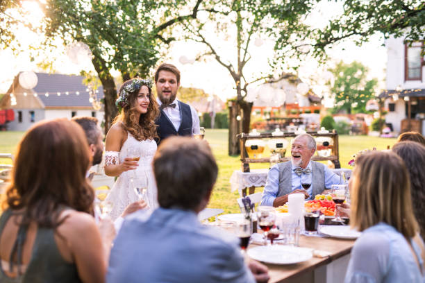 istock Bride and groom with guests at wedding reception outside in the backyard. 1038176630