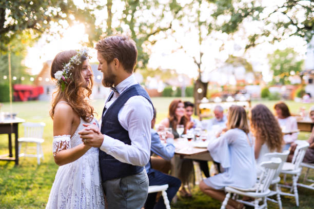 Bride and groom dancing at wedding reception outside in the backyard.