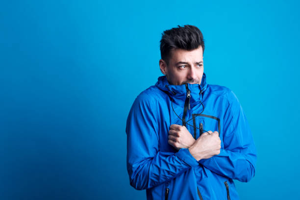 istock Portrait of a young man with blue anorak in a studio, feeling cold. Copy space. 1038180732