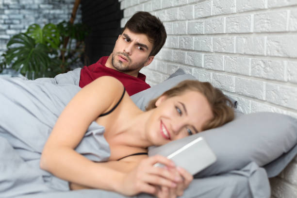 jealous boyfriend. shocked man looking at girlfriends mobile phone - infidelidade imagens e fotografias de stock