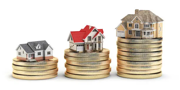 Photo of Different size houses vith different value on stacks of coins. Concept for property, mortgage and real estate investment.