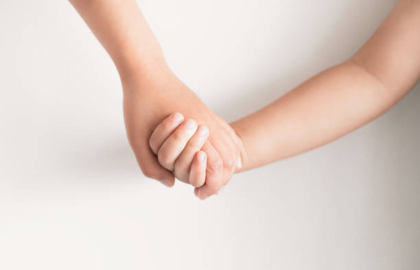 istock kids holding hand on white background 1038200856