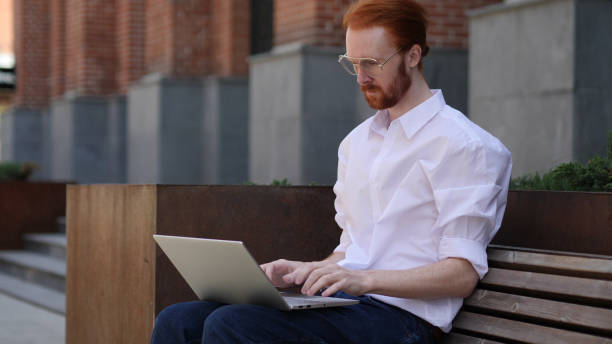 istock Designer Typing on Laptop while Sitting Outside Office 1038202142