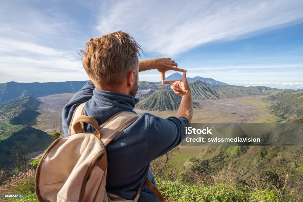 Junger Mann Wandern macht Finger Rahmen auf Vulkanlandschaft von Hügel reisekonzept Abenteuer Bromo Vulkane-Menschen betrachten - Lizenzfrei Fingerrahmen Stock-Foto