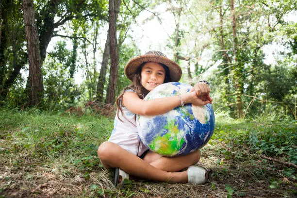 Photo of Little girl embracing world globe