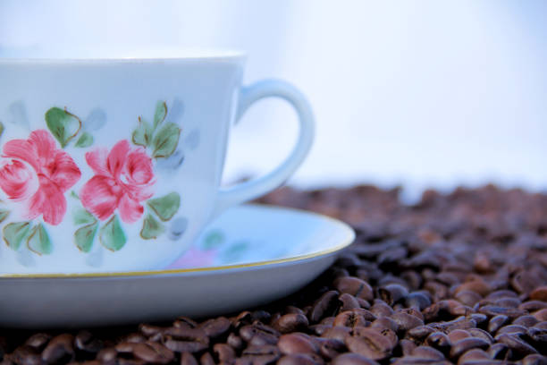 the flowered coffee cup is covered with coffee beans