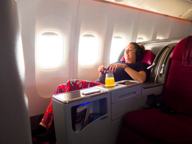 modebewusste frau, die in der businessclass fliegen flugzeug - commercial airplane airplane business travel flying stock-fotos und bilder